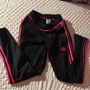 Adidas Black and pink pants with zip up pockets and zip up bottom slits